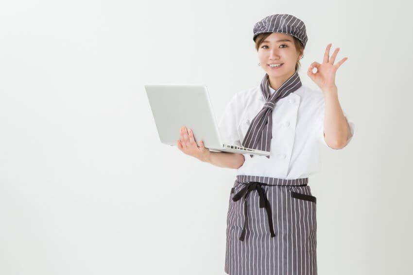 ノートパソコンを持つ女性店員